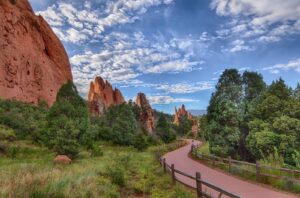 Garden of the Gods park with a wide sidewalk curving through the 150 foot tall vertical red rocks.