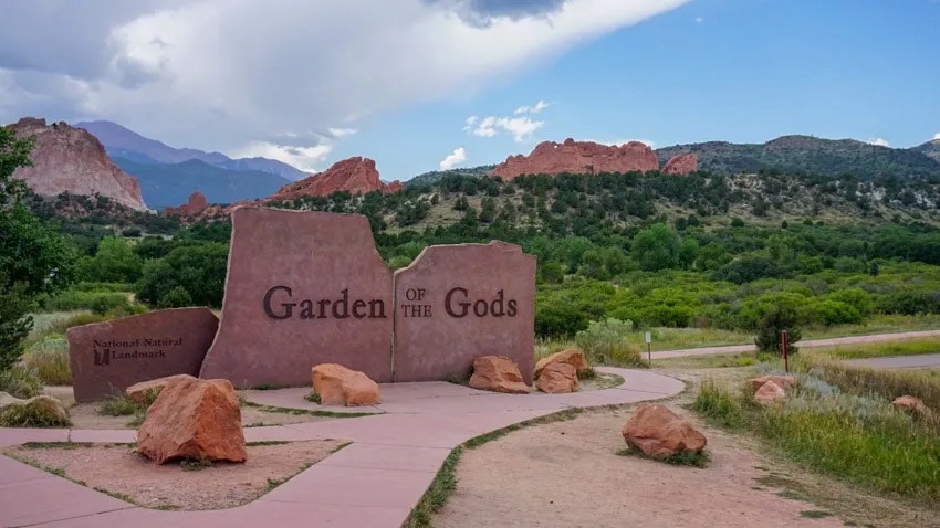 A large upright slab of red sandstone with Garden of the Gods carved into the face of it.